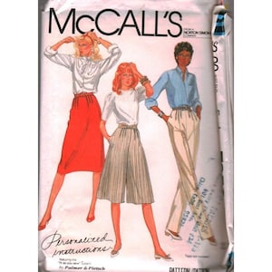 May include: A McCall's sewing pattern envelope featuring illustrations of three outfits: a white blouse with a red skirt, a white blouse with striped culottes, and a light blue button-down shirt with beige trousers. The text reads McCall's.