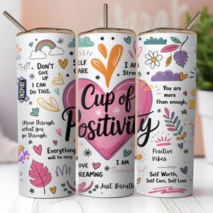 Può includere: Un bicchiere bianco con un cuore rosa che dice "Cup of Positivity" circondato da illustrazioni colorate e affermazioni positive. Il bicchiere ha una cannuccia e un coperchio.