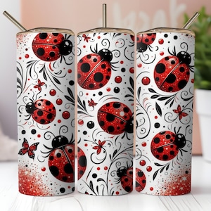 May include: Three stainless steel tumblers with a white background and a red and black ladybug pattern. The tumblers have lids and straws.