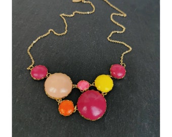 May include: A gold chain necklace with a colorful statement pendant. The pendant features six round, brightly colored stones in shades of pink, orange, yellow, and beige. The stones are set in gold.