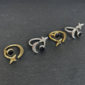 May include: Four gold and silver rings with black gemstone accents. Each ring features a crescent moon and a star design.