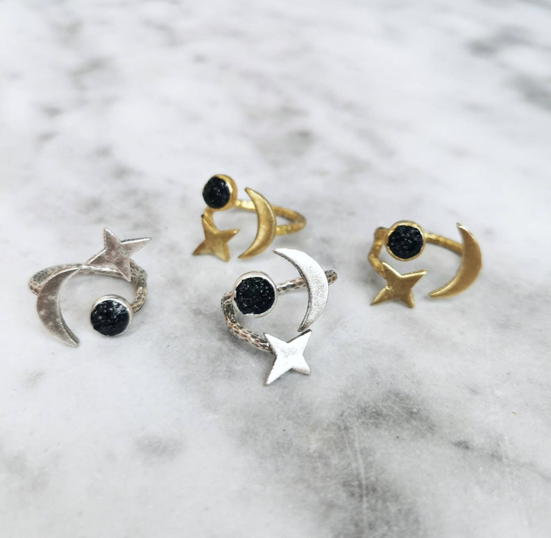 May include: Three adjustable rings featuring a crescent moon and star design. Each ring has a black stone in the centre of the moon.