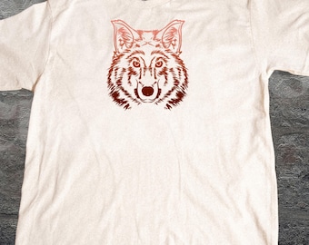 Puede incluir: Camiseta color crema con una ilustración marrón rojizo de la cabeza de un lobo. La cara del lobo está centrada, con líneas detalladas. El texto "OLD SCHOOL CURIOS" está en la parte inferior derecha de la camiseta.