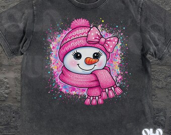 May include: Dark gray t-shirt featuring a cheerful snowman graphic. The snowman wears a pink hat with a bow, a matching scarf, and has a carrot nose. The design includes a colorful splatter effect. The text "OLD SCHOOL CURIOS" is at the bottom.