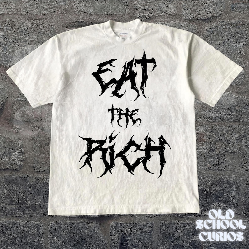 May include: White t-shirt with the text "EAT THE RICH" in a black, gothic font. The shirt has short sleeves and a crew neck. The brand name "Gildan" is visible on the collar.