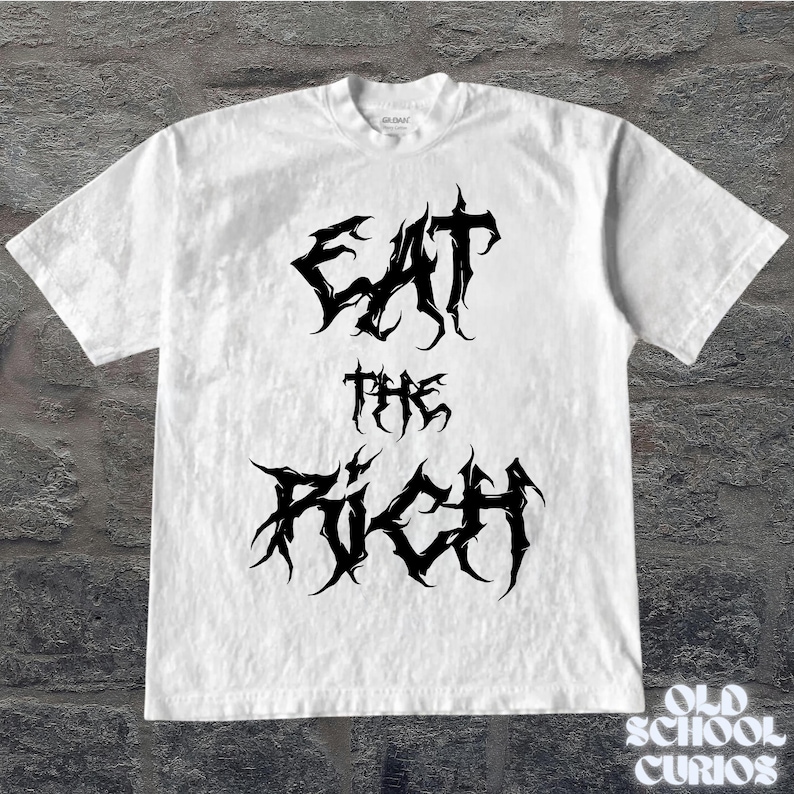 May include: White t-shirt with the text "EAT THE RICH" in a spiky, gothic font. The shirt is plain and has a crew neck. The image is set against a textured, gray background.