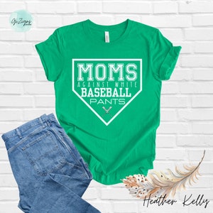 May include: Green t-shirt with a white baseball diamond graphic that says "MOMS AGAINST WHITE BASEBALL PANTS".
