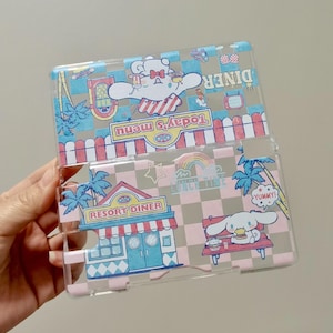 May include: Clear plastic phone case featuring cartoon diner-themed illustrations. The design includes a bear with a bow, a diner sign, palm trees, and the text "Today's menu" and "Lunch Time". The case has a pink and blue checkered pattern.