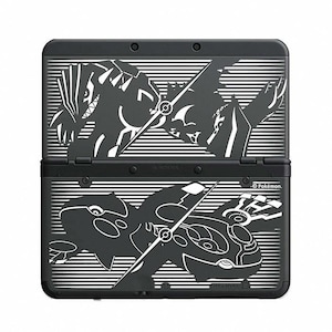 以下が含まれることがあります： 黒色のニンテンドー3DS携帯ゲーム機。白いポケモンキャラクターのグラフィックが特徴です。コンソールは開いており、上下の画面が表示されています。デザインにはポケモンのロゴが含まれています。
