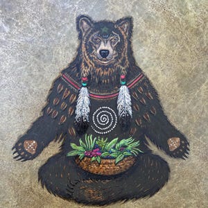 May include: A dark brown bear illustration in a seated position, featuring a green star on its forehead, two white feathers hanging from its neck, a white spiral design on its chest, and a woven basket filled with green leaves and berries.