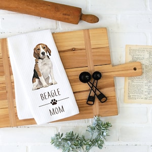 May include: White kitchen towel with a brown and white beagle dog illustration. The text "BEAGLE MOM" is printed below the dog with a paw print between the words.
