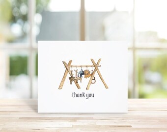 May include: A white card with a drawing of a wooden teepee with animal toys hanging from it. The text "thank you" is printed below the teepee.