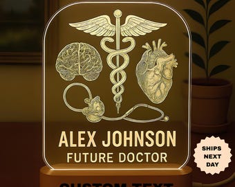 May include: A personalized night light with a wooden base. The clear acrylic panel features medical symbols, a brain, heart, and caduceus, with the text "ALEX JOHNSON FUTURE DOCTOR" and "CUSTOM TEXT". The light glows with a warm, inviting hue.