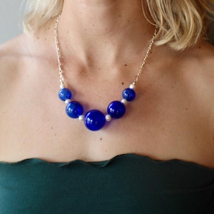 Stunning Italian blue blown glass necklace. Accented with white fresh water pearls and strung on a quality sterling silver clasp.