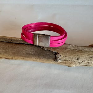 Schönes 3-reihiges italienisches Lederarmband in Rosa. Die Länge ist verstellbar und an dem Verlängerungskettchen hängt das ganze. 7&quot; lang