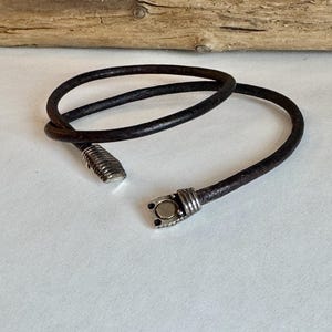 Leather bracelet, made of fine soft black Italian leather. Wrapped twice and finished with an etched magnetic clasp. Length 7&quot;.