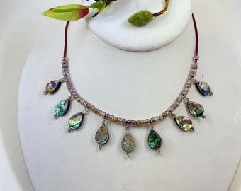 Striking abalone beaded necklace. Measures 19" long, and is finished with a quality sterling silver lobster clasp.