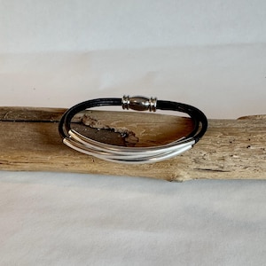 Black leather bracelet, made of fine soft Italian leather. Fashioned with three silver tubes and finished with a fine magnetic  clasp. 6.5&quot;