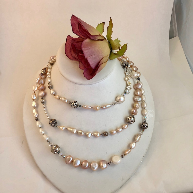 Necklace of stunning rows and rows of fresh water pearls Pearls are accented by crystals and quality sterling silver beads.