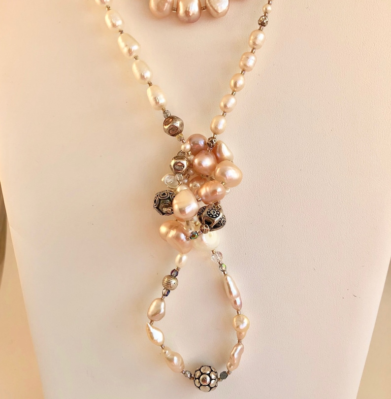 Necklace of stunning rows and rows of fresh water pearls Pearls are accented by crystals and quality sterling silver beads.