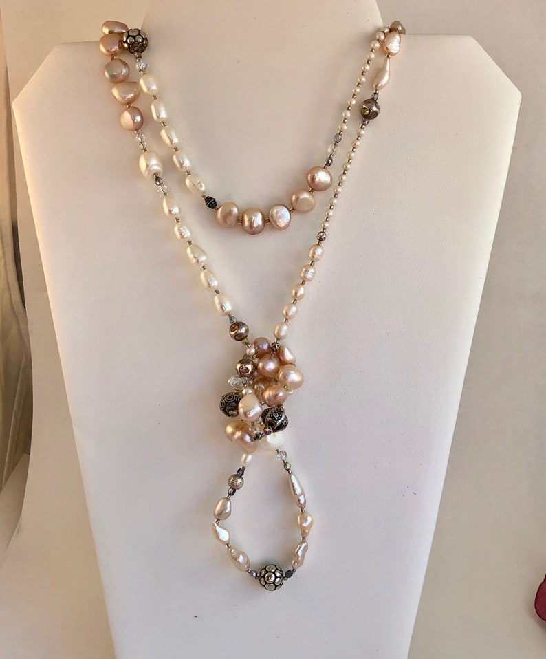 Necklace of stunning rows and rows of fresh water pearls Pearls are accented by crystals and quality sterling silver beads.