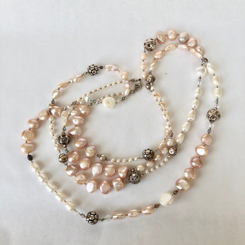 Necklace of stunning rows and rows of fresh water pearls Pearls are accented by crystals and quality sterling silver beads.