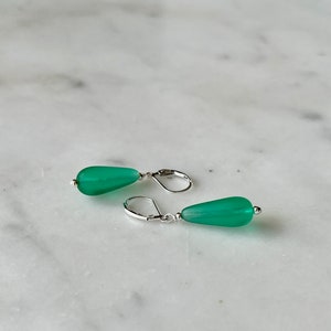 Soft sea glass type frosted green teardrop earrings. Fashioned with a quality sterling silver lever back clasp.