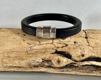 Pulsera de cuero, elaborada en fino cuero italiano negro detallado, rematada con un fuerte cierre magnético plateado.