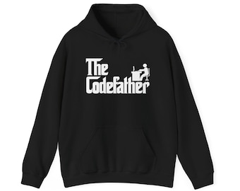 May include: A black hooded sweatshirt featuring a white graphic print on the chest. The design includes the text The Codefather in a stylized font, accompanied by a small white icon of a person sitting at a desk with a computer.