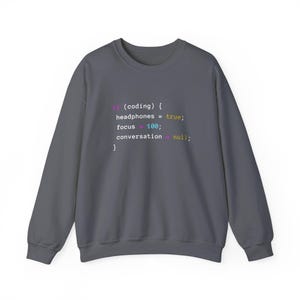 May include: A charcoal gray crewneck sweatshirt featuring a colorful code snippet printed on the chest that reads: if (coding) { headphones = true; focus = 100; conversation = null; } with syntax highlighting in pink, yellow, blue, and white.
