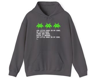 Puede incluir: Una sudadera con capucha gris carbón que presenta tres gráficos de alienígenas pixelados en verde brillante sobre un texto blanco que dice: 99 LITTLE BUGS IN MY CODE; 99 LITTLE BUGS >TAKE ONE DOWN; PATCH IT AROUND... 129 LITTLE BUGS IN MY CODE. >_