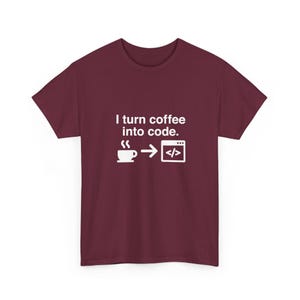 May include: A maroon short-sleeved t-shirt featuring white text that reads I turn coffee into code. Below the text is a white graphic of a coffee cup, an arrow pointing to the right, and a computer window icon containing code brackets.