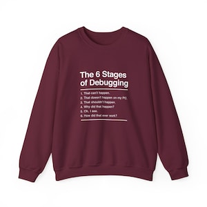 May include: A maroon long-sleeve crewneck sweatshirt featuring white text that reads: The 6 Stages of Debugging. 1. That can't happen. 2. That doesn't happen on my PC, 3. That shouldn't happen. 4. Why did that happen? 5. Oh, I see. 6. How did that ever work?
