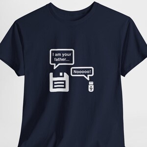 Puede incluir: Camiseta azul marino con un diseño blanco. El diseño muestra un disquete diciendo "I am your father..." y una unidad USB respondiendo "Nooooo!". Un diseño divertido para los amantes de la tecnología.
