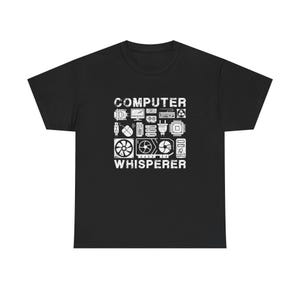 Könnte beinhalten: Schwarzes T-Shirt mit einem weißen Grafikdesign mit Computerkomponenten und den Worten "COMPUTER WHISPERER". Das Design enthält Bilder eines Computermonitors, einer Maus, eines Lüfters und anderer technischer Symbole.