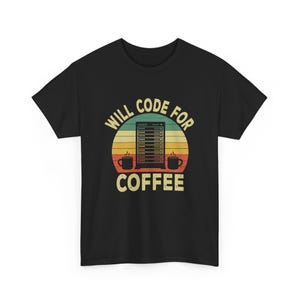 May include: A black short-sleeve t-shirt featuring a graphic with a server rack flanked by two coffee mugs over a sunset-colored circle. The text reads WILL CODE FOR COFFEE in a distressed font, centered around the server rack illustration.
