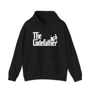 Op de afbeelding: Zwarte hoodie met witte tekst "The Codefather" en een programmeur-icoon. De sweatshirt heeft een voorzak en een capuchon met trekkoord. Een casual, comfortabel kledingstuk.