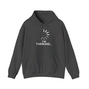 May include: A dark grey hooded sweatshirt featuring a white and light grey circular loading icon graphic centred on the chest. Below the icon, the text I'M THINKING... is printed in a white, sans-serif, block-style font.