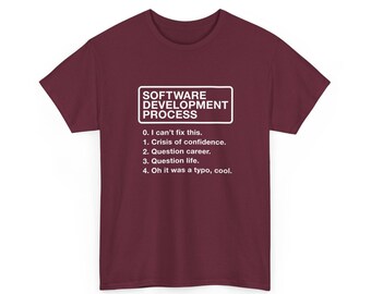 May include: A maroon short-sleeved t-shirt featuring white text that reads: SOFTWARE DEVELOPMENT PROCESS 0. I can't fix this. 1. Crisis of confidence. 2. Question career. 3. Question life. 4. Oh it was a typo, cool.