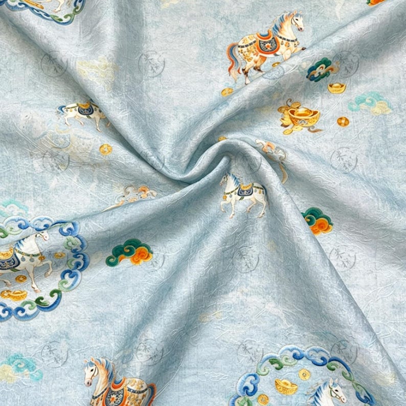 May include: Light blue fabric with a repeating pattern of horses, clouds, and gold ingots. The horses are adorned with colorful saddles and bridles. The fabric has a subtle, textured appearance.