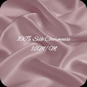 以下が含まれることがあります： モーヴ色のシルクシャルムーズ生地の見本をクローズアップ。生地はドレープされ、折りたたまれており、柔らかい影とハイライトを作り出しています。「100% Silk Charmeuse」と「16M/M」の文字が生地にプリントされています。