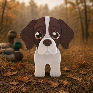 May include: A brown and white dog-shaped decoration with large, expressive eyes. The dog has brown ears and a white stripe down its head. The background features ducks and autumn foliage, creating a seasonal theme.