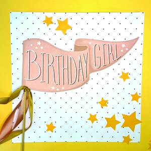 May include: A pink banner with the text "Birthday Girl" on a white background with black polka dots and yellow stars.