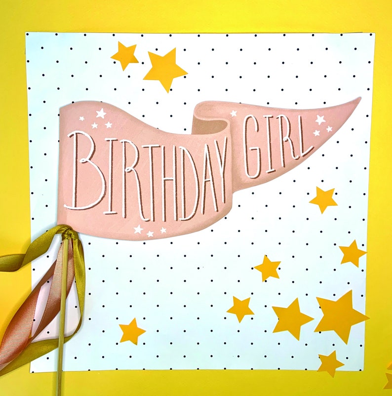 May include: A pink banner with the text "Birthday Girl" on a white background with black polka dots and yellow stars.