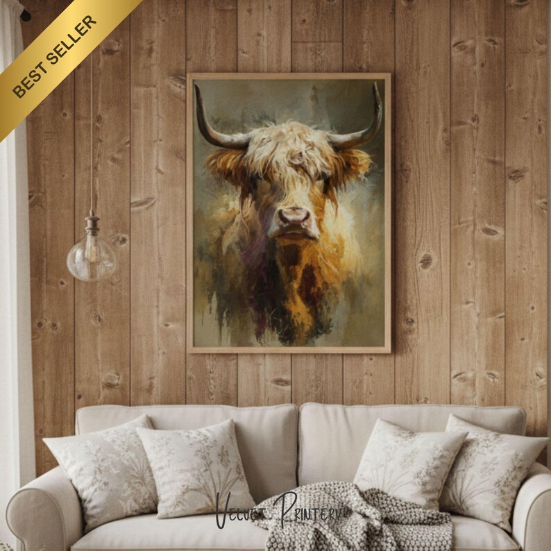 May include: A framed art print of a Highland cow with long, shaggy fur and large horns. The artwork features warm tones of brown, gold, and tan, creating a rustic and inviting aesthetic. The print is displayed on a wooden wall.