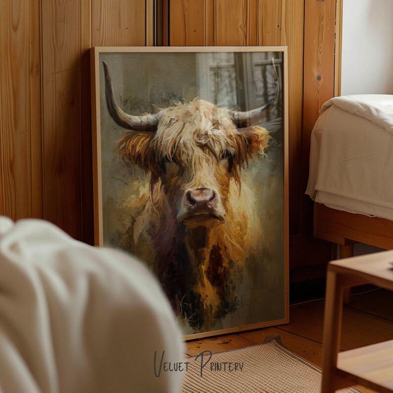 May include: A framed print featuring a detailed portrait of a Highland cow. The artwork showcases the cow's shaggy, light brown fur and large horns. The print is set in a wooden frame, adding a rustic touch to the artwork.