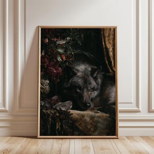 Könnte beinhalten: Gerahmter Kunstdruck mit einer detaillierten Malerei eines dunkelgrauen Wolfs in Ruhe. Der Wolf ist von dunkelrotem und grünem Laub sowie einem goldenen Vorhang umgeben. Das Kunstwerk ist in einem Holzrahmen gefasst.