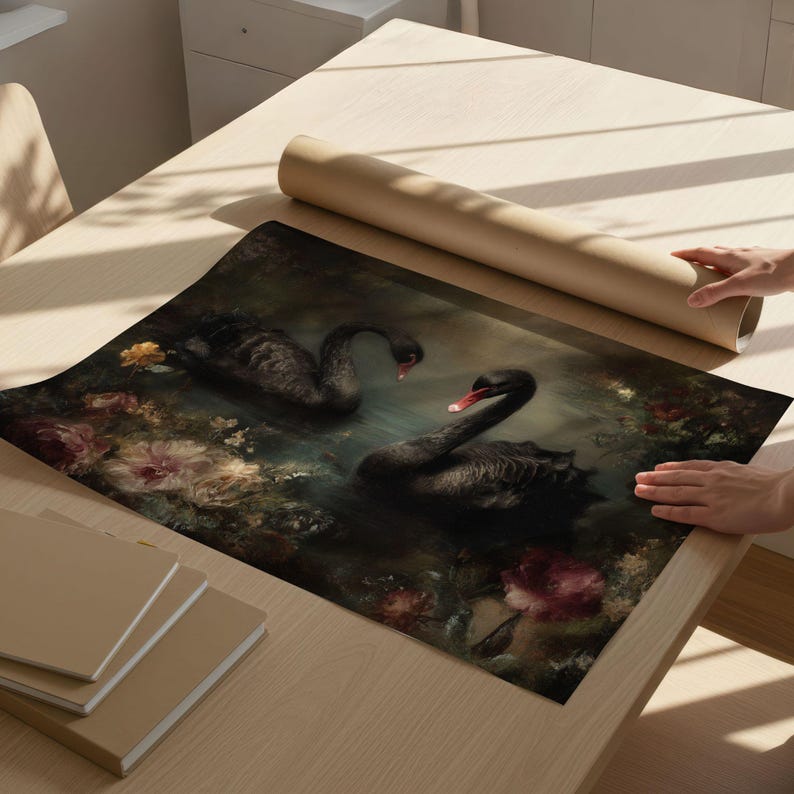 May include: A print featuring two black swans with red beaks swimming in a pond surrounded by flowers. The artwork has a dark, moody aesthetic with a focus on the swans and floral elements.