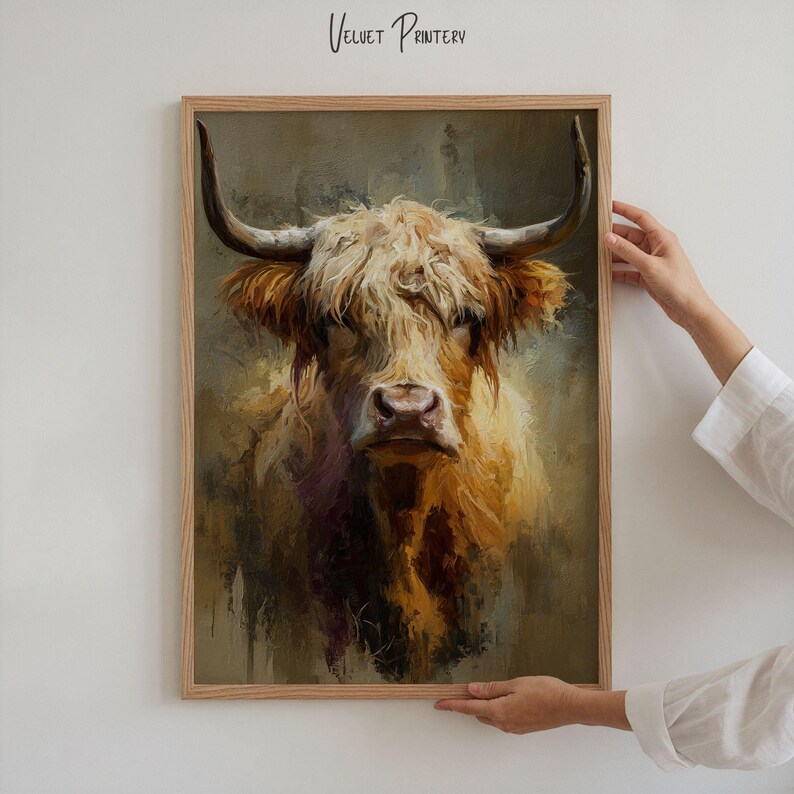 May include: A framed print featuring a detailed portrait of a Highland cow. The artwork showcases the cow's shaggy, light brown fur and large horns. The print is in a wooden frame, with the text "Velvet Printery" at the top.