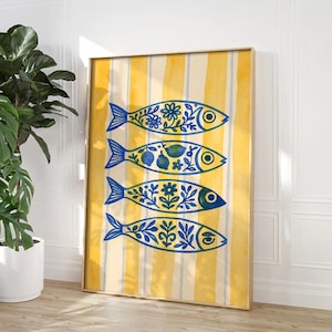 May include: A framed art print featuring four stylized fish in blue and yellow. Each fish is decorated with floral and fruit patterns. The background has vertical yellow and white stripes. The artwork is displayed in a room with a plant.